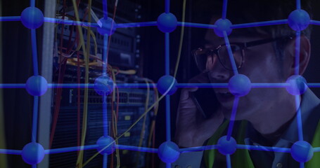 Holding smartphone technician managing digital network nodes in server room with cables, copy space