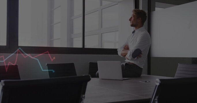 Sitting male professional gazing through windows at conference table, with laptop and graph overlay