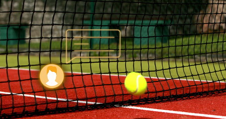 Pressing yellow tennis ball under net on red court with white lines chain-link fence, copy space