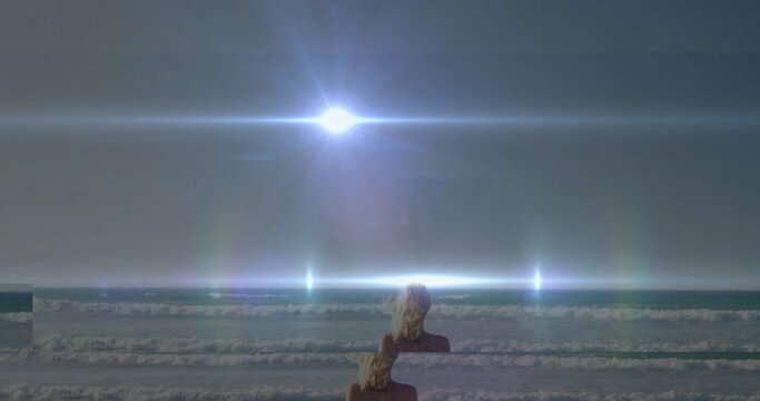 Blonde-haired swimmer wading waves in open ocean reflecting rainbow lens flares from light source - Powered by Adobe