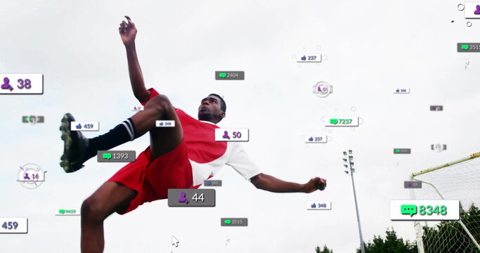 Leaping soccer player wearing red uniform on field, with goal net and social media overlays