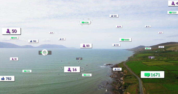 Fototapeta Floating digital overlay icons hovering over narrow coastal road by rocky shoreline, green fields