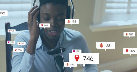 Speaking woman wearing blue shirt and headset at home office desk, with microphone and alert icons