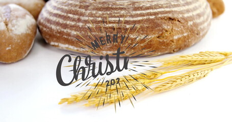 Showing artisan loaf with two rolls, wheat stalks on white table, Merry Christmas 2017 graphic