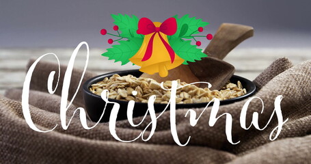 Displaying bowl holding oats with scoop on table featuring cursive Christmas text, holly and bells