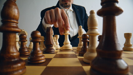 Unknown man playing chess logic board game closeup. Player hand moving figure © stockbusters