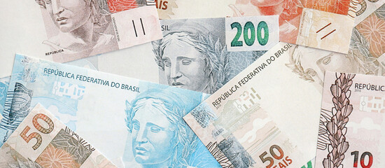 Brazilian reais banknotes. The current Brazil real money bills lies on table in big amount