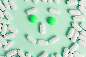 A smiley face made of pills on a light green background. The image conveys feelings of happiness...