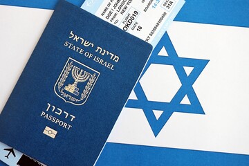 Israel passport and tickets on flag. The current Israel biometrical pass lies on flag close up