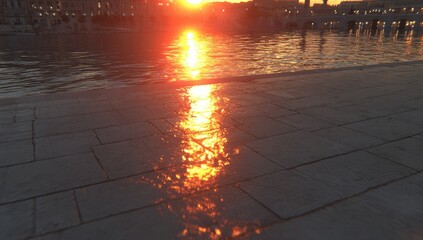 Sunset reflections on water and stone paving