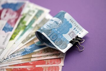Pakistan rupees banknotes on purple background. The current Pakistan money bills