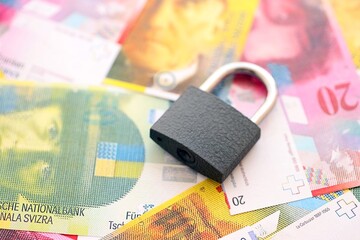 Swiss franc banknotes and padlock. The current francs money bills with lock lies in big amount