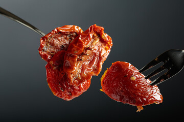 Sun dried tomatoes in olive oil on a fork.