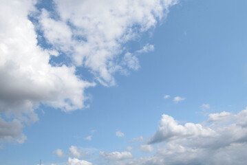 Blue sky adorned with drifting clouds at midday in a tranquil setting