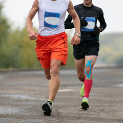 two man runners running in river embankment marathon race