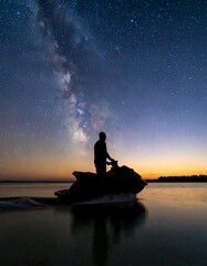 Silhouette of person on jet ski at night, Milky Way