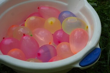 Colorful Water Balloons in a Bucket for Outdoor Fun