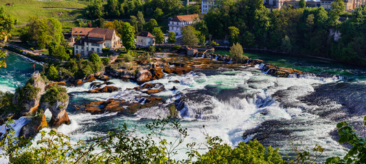 Switzerland tourism . Rheinfall (Rhine Falls) biggest waterfall in Europe in Schaffhausen , panoramic view with Laufen castle . Swiss - German border.