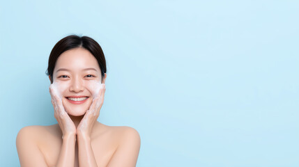 Smiling Woman Gently Cleansing Her Face with Lathered Soap in Soft Blue Background