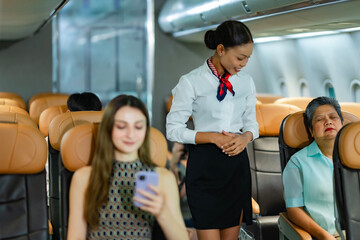 Air hostess monitoring passenger area during preflight check, ensuring all passengers are seated, belts fastened, and belongings stored properly before takeoff.