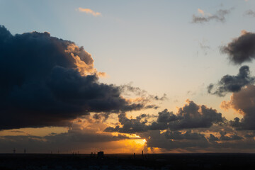 Stunning sunset scene featuring vibrant clouds and golden light illuminating the horizon, creating a serene atmosphere and captivating view
