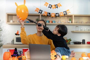 Halloween Celebration. Mother and son playing with balloons and festive decorations.