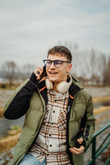 Young caucasian man student smiling and using smartphone 