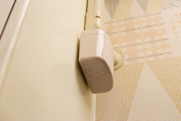 Wall-mounted drain pump for air conditioner with water droplets underneath, indicating malfunction...