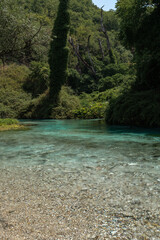 Fototapeta premium Vertical photo of Blue Eye spring (Syri i Kalter) in southern Albania, featuring turquoise water, forest surroundings, and vibrant nature.