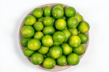 Fototapeta premium a bowl of limes on a white surface