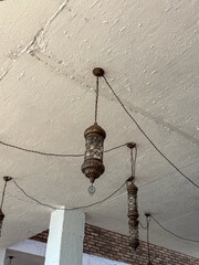 Elegant vintage lanterns hanging from a ceiling, adding a warm ambiance to the space.