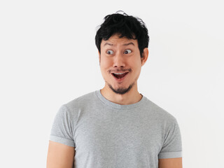 Thai man smiling with happy and amused facial expression on white studio background
