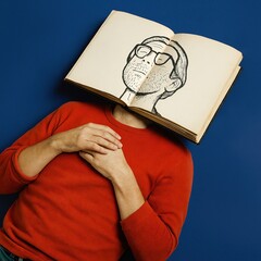 Book face illusion with illustrated head replacing real face against blue background
