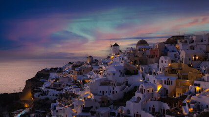 Landscape during sunsetlight at Oia village, Santorini, Greece. View of traditional houses in Santorini. Small narrow streets and rooftops of houses, churches and hotels.