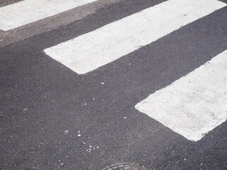 A Close Up View of a Pedestrian Crossing Marked by White Stripes on Asphalt Road Surface Providing...