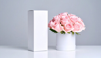 Elegant Arrangement: A delicate composition of soft pink roses in a circular container with a minimalist white rectangular package, perfectly arranged on a reflective surface.