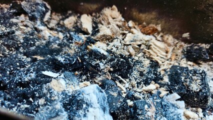 the remains of burning using charcoal, some of which has turned to ash