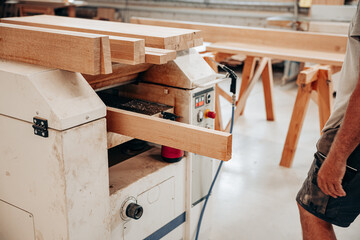 Woodworker Planing Oak Beam in Carpentry Workshop