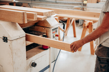 Woodworker Planing Oak Beam in Carpentry Workshop