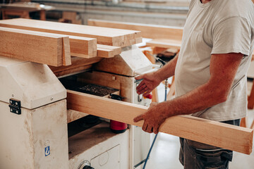 Woodworker Planing Oak Beam in Carpentry Workshop