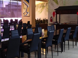 Elegant Restaurant Interior with Black Chairs Tropical Decor and Buffet Setup.