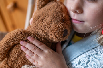 little child, preschool girl 5 years old plays with toy, hugs teddy bear, happy childhood,...