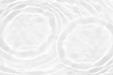 White water with ripples on the surface. Defocus blurred transparent white colored clear calm water surface texture with splashes and bubbles. Water waves with shining pattern texture background.
