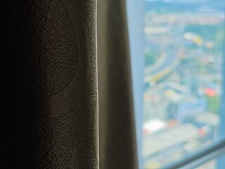 Textured Curtain Edge with Blurred Cityscape View Soft Light Interior Detail.