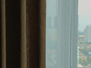 Textured Curtains Framing a Distant Cityscape Soft Light and Subtle Patterns.