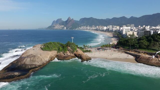 Aerial drone shot of Ipanema Beach and Pedra do Arpoador on a sunny day in Rio de Janeiro, Brazil.	
