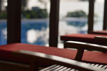 Tranquil Poolside Loungers Red Cushions and Serene Water Reflections.