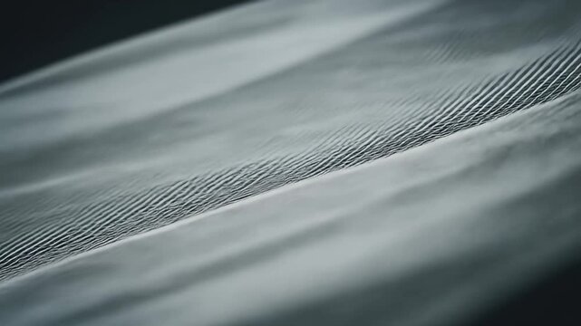 Diagonal silver textured surface with soft highlights and dark shadows, slightly blurred