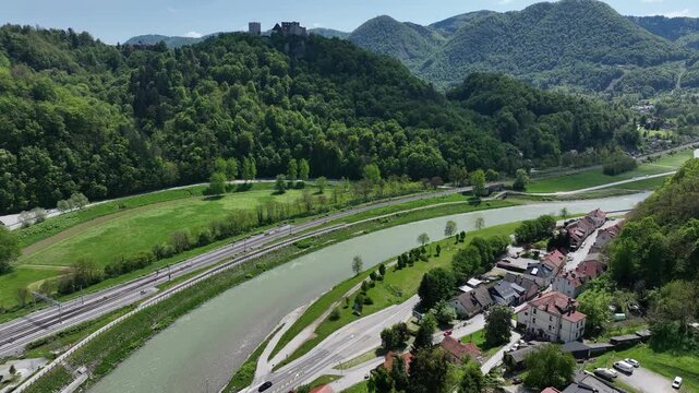 Aerial views of Slovenian landscapes in spring. Drone footage of Celje and its fortress. Historic Celje Castle overlooks vibrant spring townscape, combining medieval legacy and modern life.