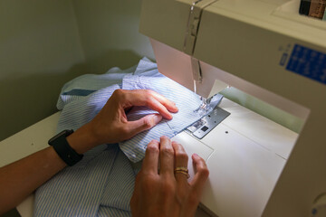 A woman sewing at home. Creating own clothes.